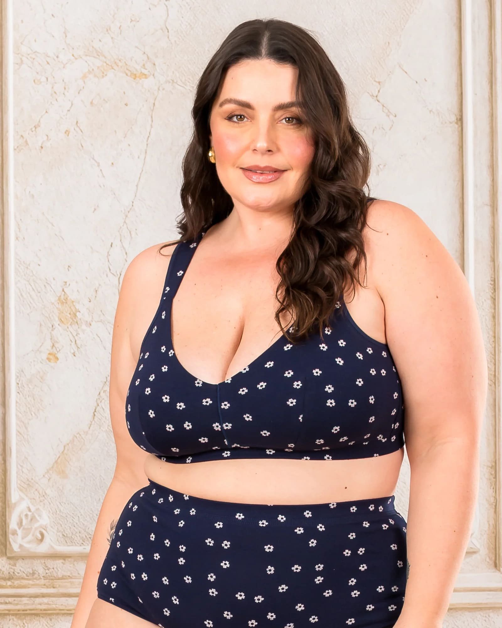 modelo com conjunto de sutia e calcinha de cor azul escuro e estampa de flor de tecido respiravel e macio