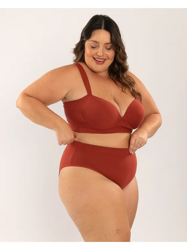 modelo de lado segurando no cos da calcinha com sutia cor terra e calcinha sustentacao plus size terra
