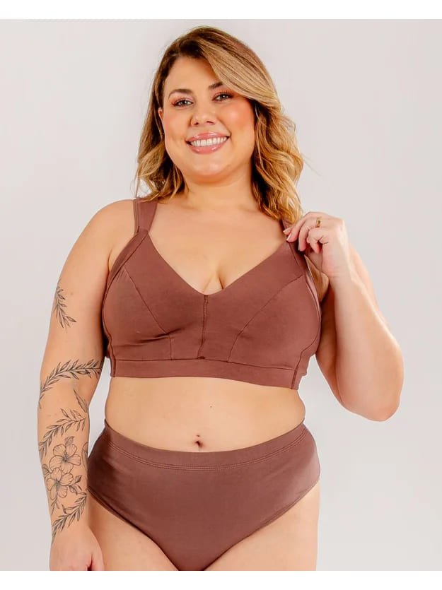 modelo sorrindo segurando alca do sutia sem bojo malu plus size chocolate que ela esta usando