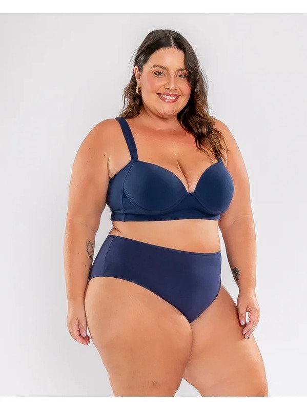 modelo levemente de lado olhando pra frente usando sutia azul marinho e calcinha basica plus size marinho